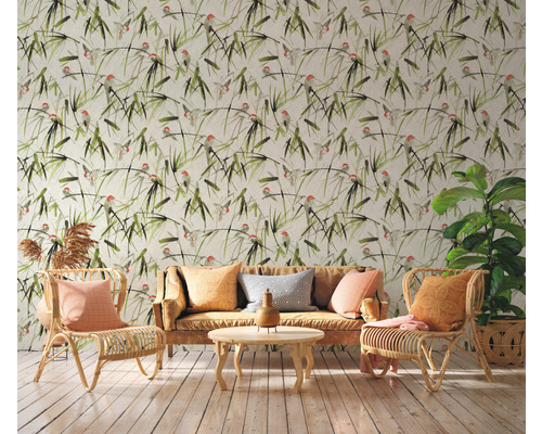 Wohnzimmer mit gemusterter Tapete, Sofa und Rattansesseln