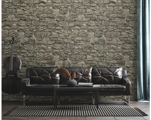 Wohnzimmer mit Steinwand, Ledersofa und Cello