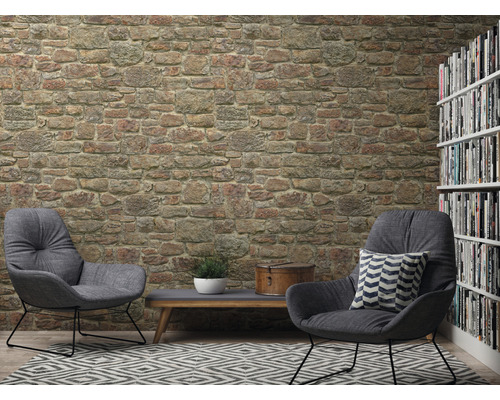 Wohnzimmer mit Steinwandtapete, zwei Sesseln, Teppich und Bücherregal