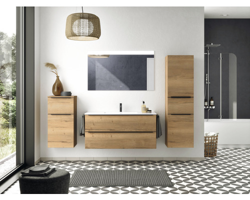 Badezimmer mit Waschtisch, Spiegel, Hängeschränken, Badewanne und gemustertem Boden