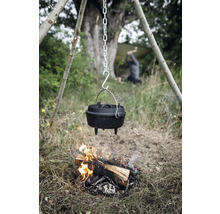 Gusseiserner Dutch Oven hängt über einem Lagerfeuer im Freien.