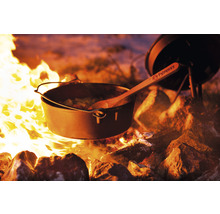 Gusseiserner Dutch Oven mit Holzkochlöffel über offenem Feuer