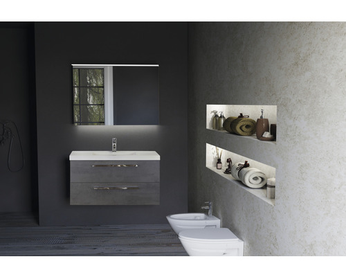 Badezimmer mit Waschtischunterschrank, Spiegel mit Beleuchtung, Bidet und Toilette.