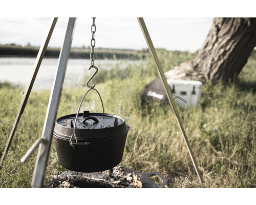 Gusseisen-Dutch Oven hängt über einem Lagerfeuer an einem Dreibein.