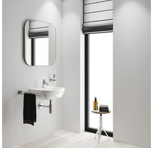 Helles Badezimmer mit Waschbecken, Spiegel und Fenster.