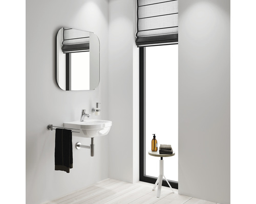 Helles Badezimmer mit Waschbecken, Spiegel und Fenster.