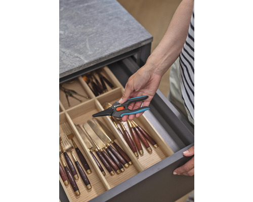 Eine Person nimmt eine Gardena Pflanzenschere aus einer Schublade mit Besteck.