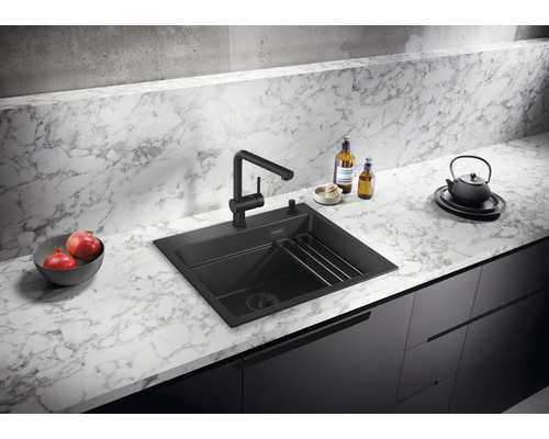 Schwarze Küchenspüle mit Wasserhahn auf einer Küchentheke.
