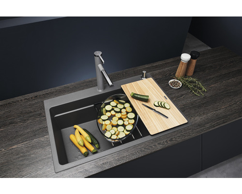 Spüle mit Armatur, Schneidebrett und Zucchini auf einer Küchentheke