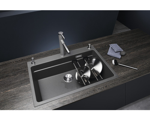 Spüle mit Abtropfgestell, Spülmittelspender und Küchenarmatur auf einer Arbeitsplatte