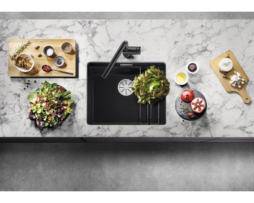 Draufsicht auf eine Küchenspüle mit Armatur und Lebensmitteln auf einer Küchentheke