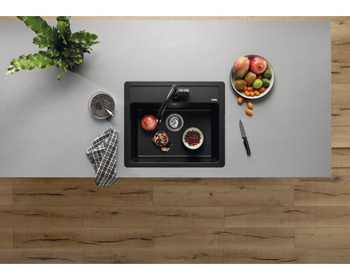 Ansicht von oben auf eine Spüle mit Armatur und Obstschale auf einer Arbeitsplatte.