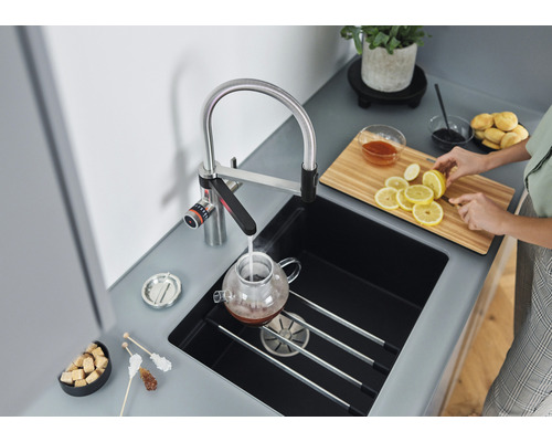 Küchenszene mit Armatur, Spüle, Schneidebrett und Zubereitung von Tee