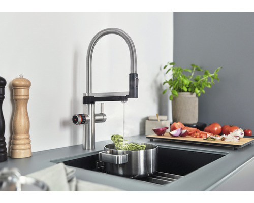 Küchenszene mit Spültischarmatur, Spüle und diversen Küchenutensilien