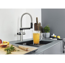 Küchenszene mit Spültischarmatur, Spüle und Küchenutensilien.