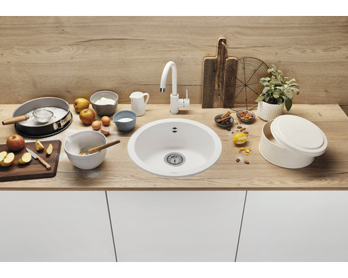 Küchenszene mit Spüle, Armatur und Backzutaten auf einer Arbeitsplatte.