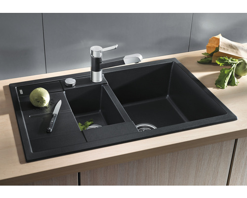 Spüle mit Abtropffläche, Armatur und Gemüse auf einer Küchentheke.