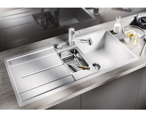 Spüle mit Abtropffläche, Spülbecken, Küchenarmatur und Zubehör auf einer Küchentheke.