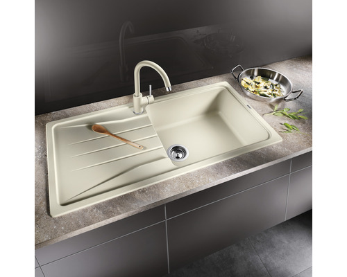 Beige Küchenspüle mit Abtropffläche und passender Armatur auf einer Küchentheke.