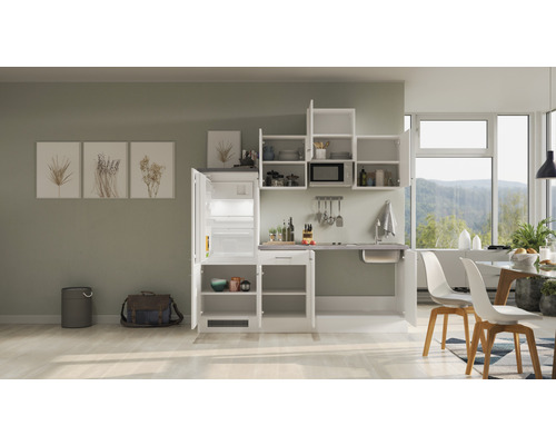 Küchenzeile mit Kühlschrank, Spüle und Hängeschränken in einem hellen Raum