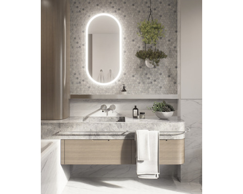 Badezimmer mit Waschtisch, beleuchtetem Spiegel und Dekoration