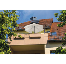 Balkon mit Sonnenschirm und Bepflanzung vor einem Haus