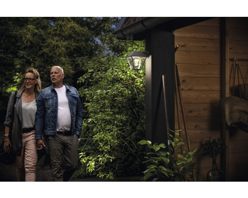 Szene mit einem Paar vor einem Haus mit einer Außenwandleuchte.