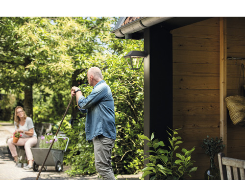 Szene mit Außenwandleuchte, Personen und Gartenelementen