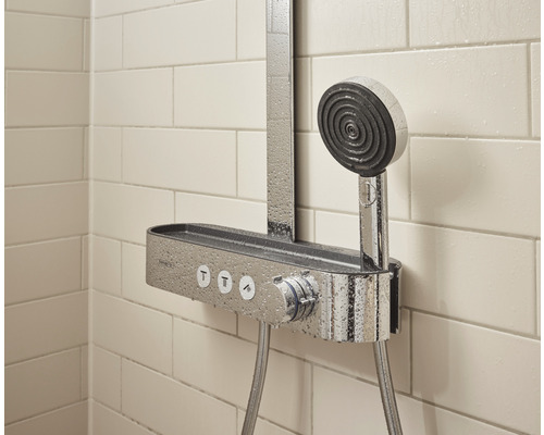 Duschsystem mit Handbrause und Ablage vor einer gefliesten Wand