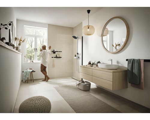 Helles Badezimmer mit Dusche, Waschtisch, Spiegel und Accessoires für ein modernes Ambiente