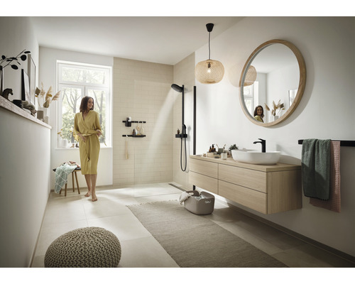 Helles Badezimmer mit Dusche, Waschtisch mit Spiegel, Handtuchhalter und Sitzgelegenheit