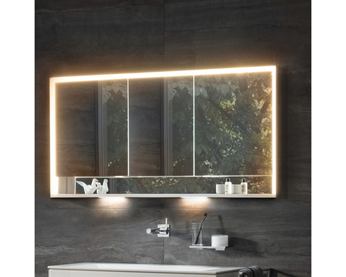 Badezimmer mit beleuchtetem Spiegelschrank, Ablage und Badaccessoires