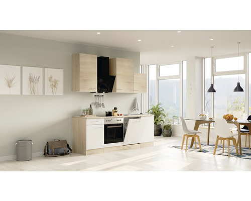 Helle Küche mit Einbaugeräten, Küchenschränken und Essbereich in einem geräumigen Zimmer.