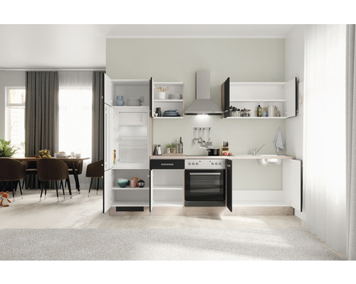 Einbauküche mit Kühlschrank, Herd, Spüle und Hängeschränken in einem hellen Raum