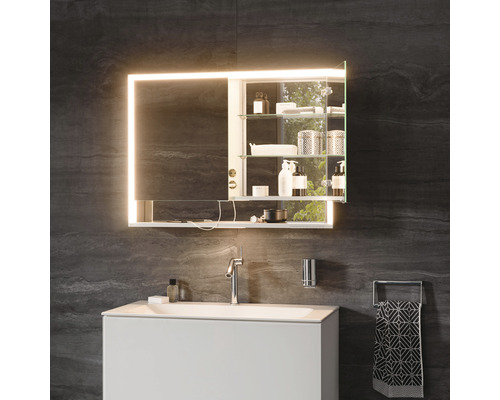 Badezimmer mit beleuchtetem Spiegelschrank, Waschbeckenunterschrank, Armatur und Handtuchhalter