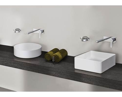 Badezimmer mit runden und rechteckigen Aufsatzwaschbecken, Armaturen und Handtüchern auf einem dunklen Regal