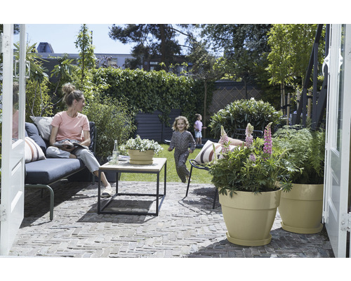 Garten mit Sitzgelegenheit, Tisch und bepflanzten Übertöpfen