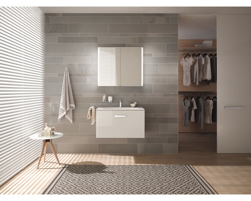 Modernes Badezimmer mit Waschtisch, Spiegelschrank, Handtüchern und Teppich