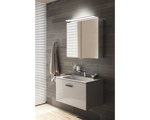 Modernes Badezimmer mit Waschbeckenunterschrank und Spiegelschrank inklusive Beleuchtung an einer grauen Wand.