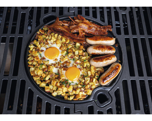 Gegrilltes Frühstück mit Eiern, Speck, Würstchen und Bratkartoffeln auf einer Grillplatte
