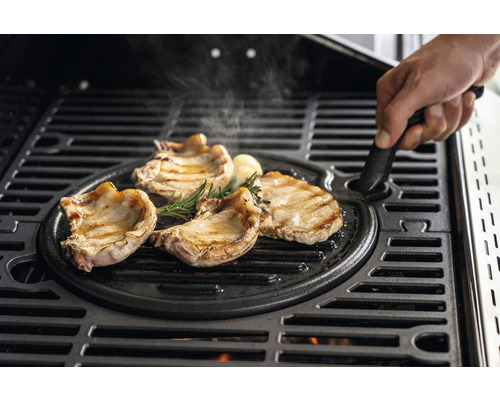Fleisch, Rosmarin und Knoblauch auf einer Grillplatte aus Gusseisen