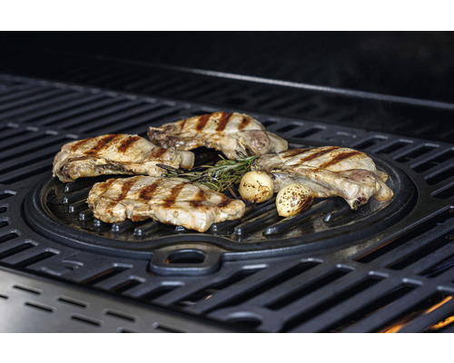 Fleischstücke und Knoblauch auf Grillplatte