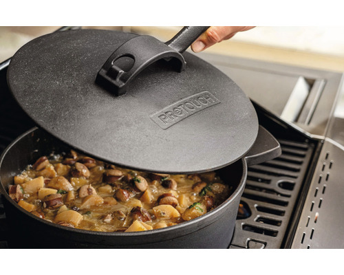 Gusseisen Topf mit Deckel auf einem Grill mit Speisen