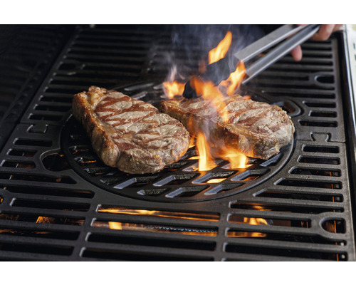 Zwei Steaks werden auf einem Grill mit Flammen gegrillt