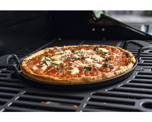 Pizza auf Grillplatte mit Griffen auf einem Grill