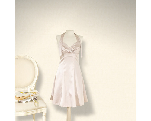 Kleid mit Neckholder auf einer Schneiderpuppe neben einem Stuhl