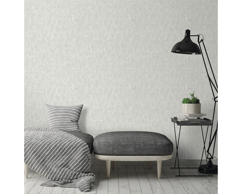 Wohnraum mit gemusterter Tapete, Sitzgelegenheit, Kissen, Decke und Stehlampe