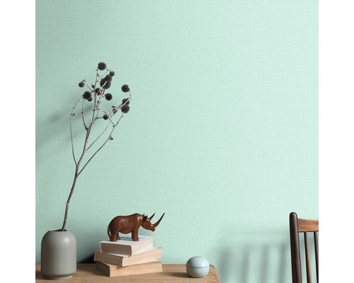 Dekorative Wandgestaltung mit Vase, Dekoration und Bücher auf einem Tisch vor einer Wand