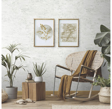 Heller Raum mit hellgrauer Mustertapete, botanischen Kunstdrucken, Rattansessel, Pflanzen und Holzelementen.