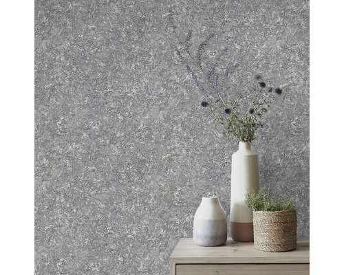 Graue Vliestapete mit abstrakter Struktur und Pflanzen in Vasen auf Kommode